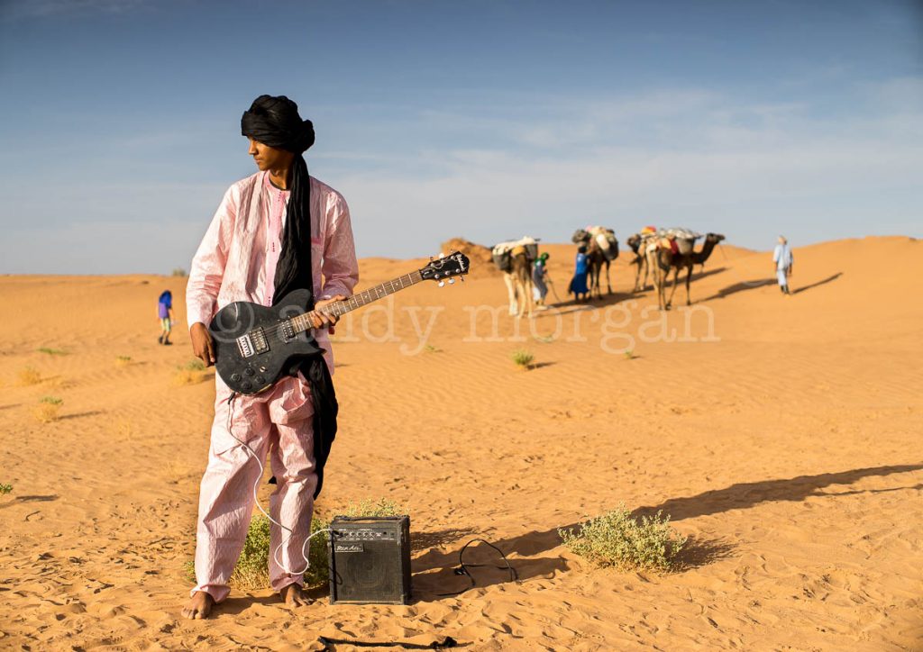 A member of Les Jeunes Nomades with caravan in background