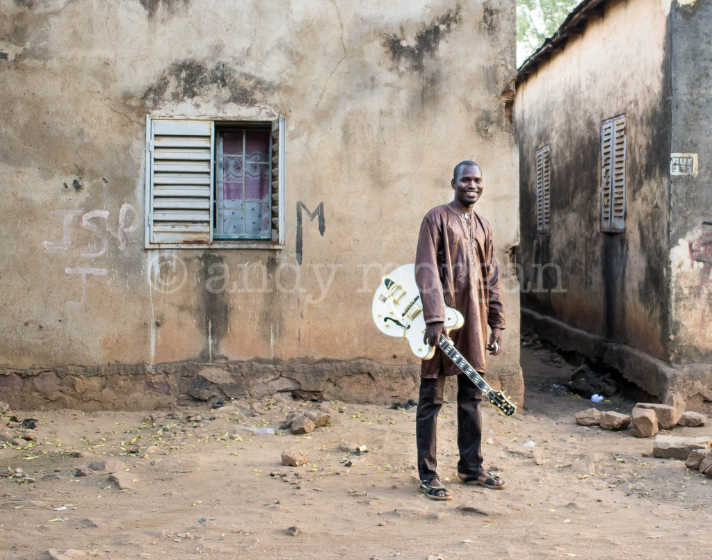 Garba on the streets of Bamako with his white semi-acoustic guitar, 2014. Photo: Andy Morgan.