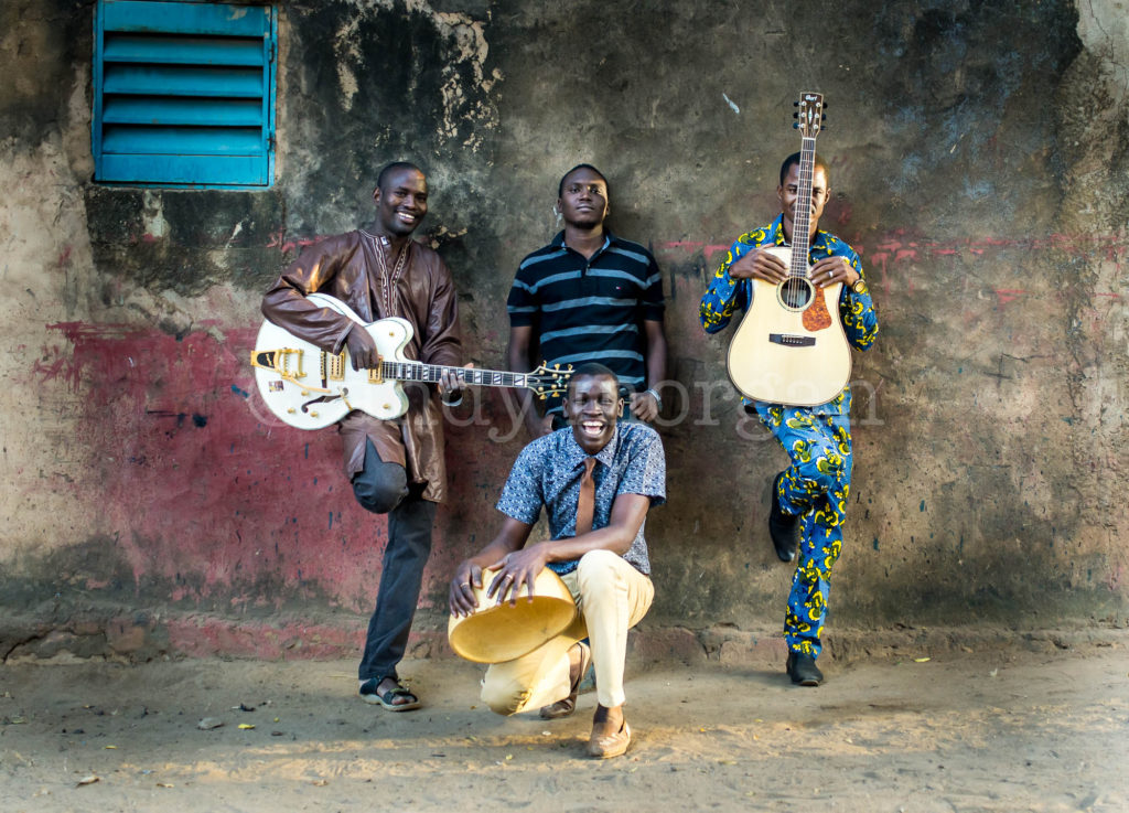 Songhoy Blues propping up the wall, Bamako, Mali - 2014. (L-R Garba, Ali, Oumar and Nat sitting). Photo: Andy Morgan